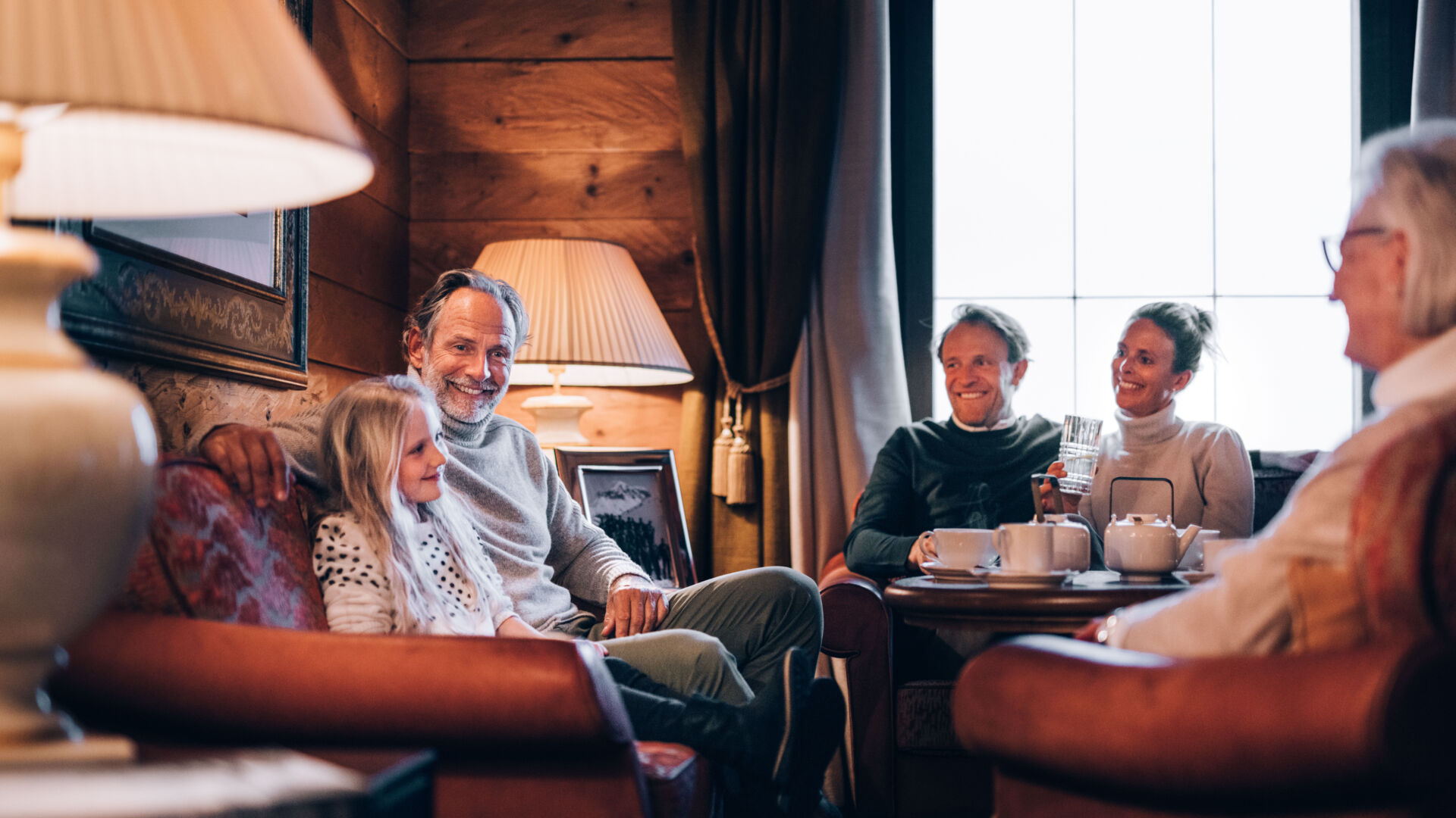Eine Familie sitzt gemeinsam im Wohnzimmer und reden miteinander