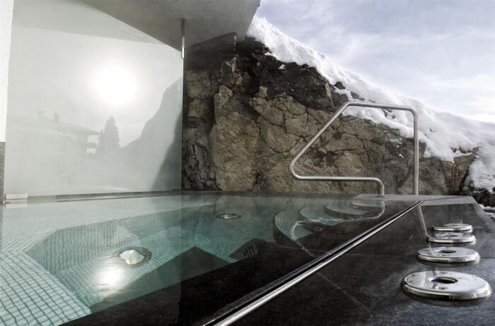 Beheizter Outdoorpool umgeben von schneebedeckter Landschaft - alpin_spa9