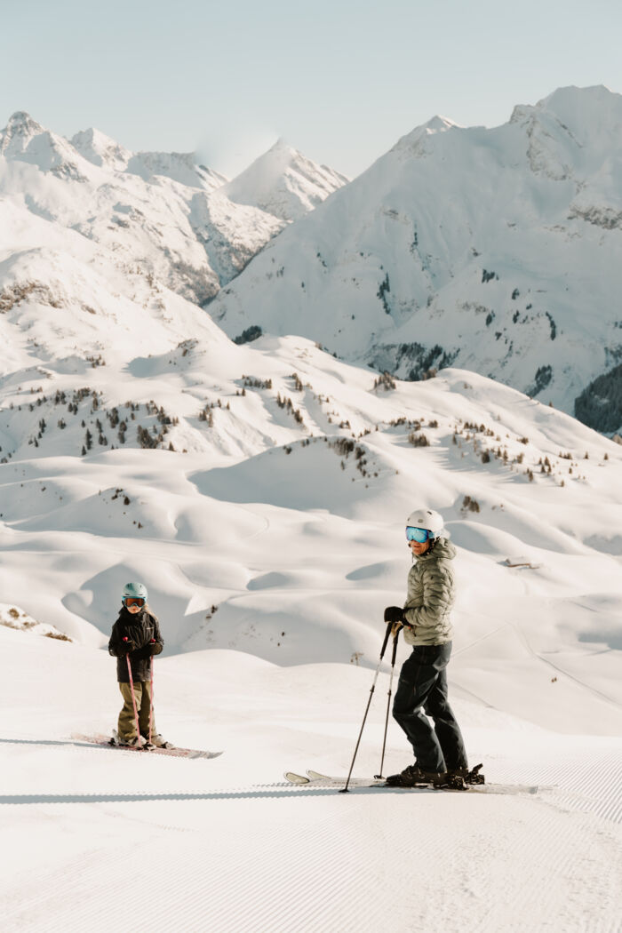 Vater mit Kind am Berg mit Schnee - Lech Zürs Skitag © Dominic-Kummer