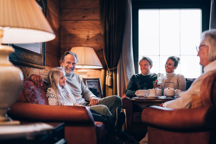 Eine Familie sitzt gemeinsam im Wohnzimmer und reden miteinander
